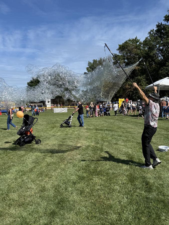 Giant bubbles floating over the field during the Bubble Extraordinaire show at Community Day 2026