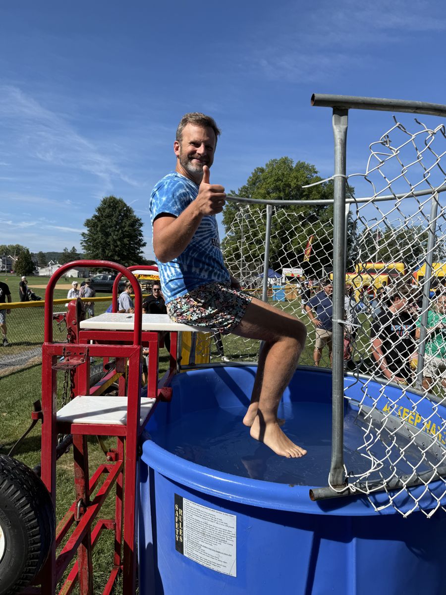 A Southern Lehigh teacher gives a thumbs up from the dunk tank seat at Community Day 2026