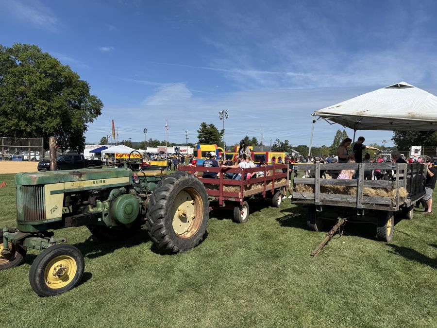 Antique tractor pulling hay wagons at Community Day 2026