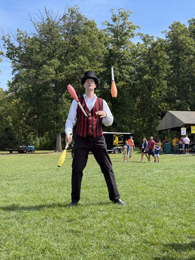 Juggler in a top hat performing on the field at Community Day 2026
